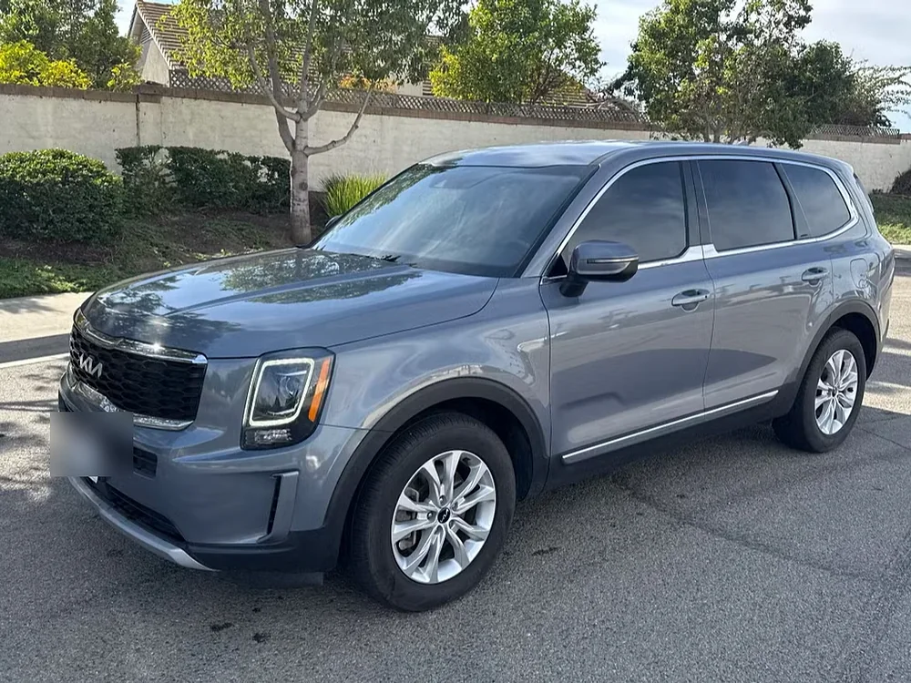 Grey Kia Telluride SUV parked on a quiet residential street