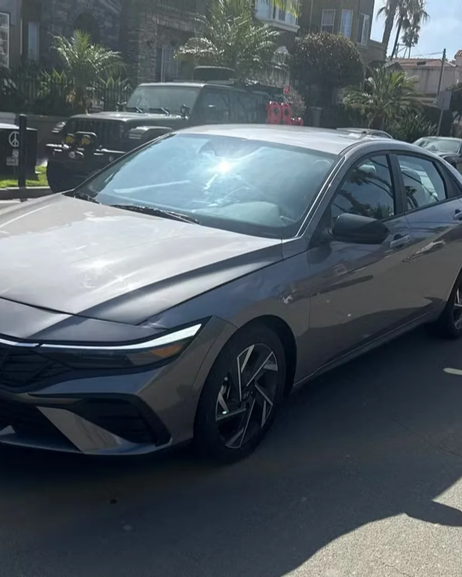 Sedan from the Evolution Auto Sale fleet on a palm-lined street in Oceanside, California